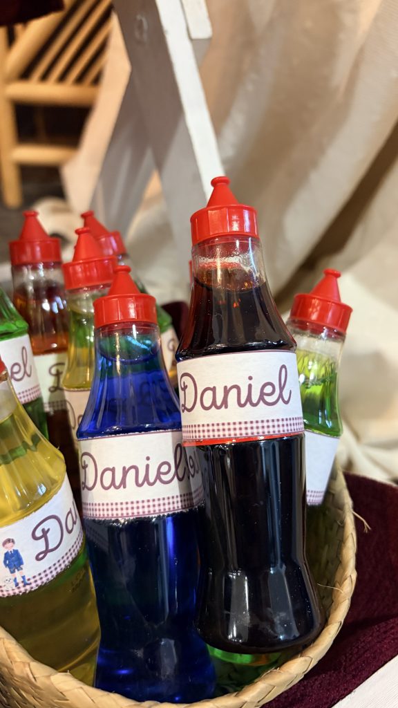 Cesta con botellitas de caramelo líquido personalizadas