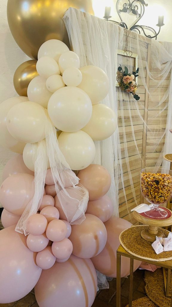 Detalle: Arco de globos orgánico en tonos rosas, dorados y crema